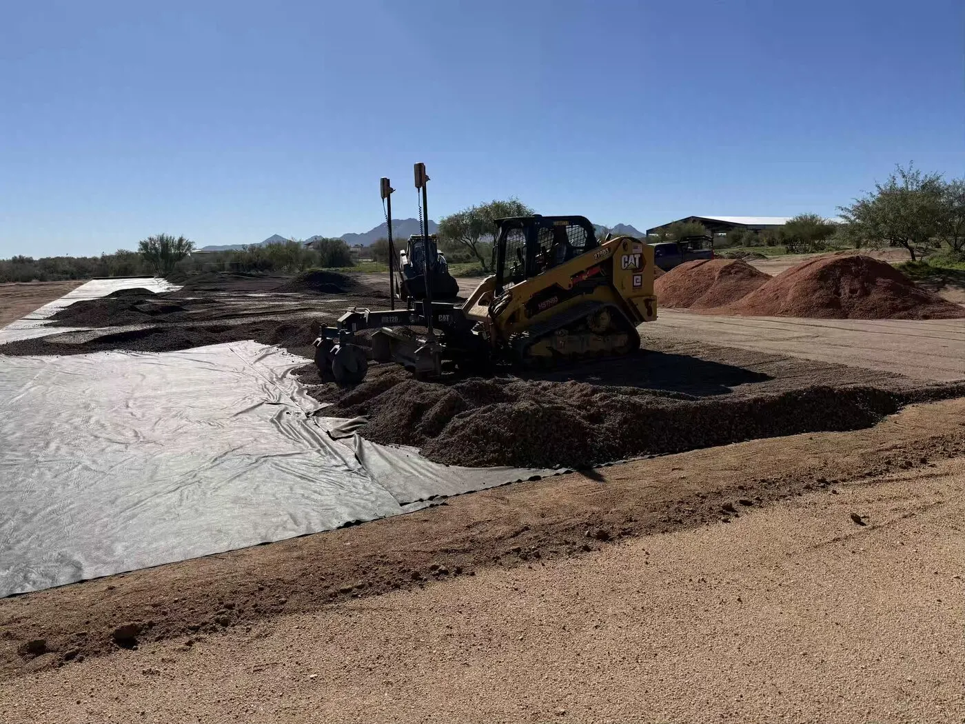 Woven geotextile separation fabric laid before base rock placement in Arizona